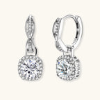 Sterling silver twisted hoop earrings with round moissanite stones in halo settings against neutral background.