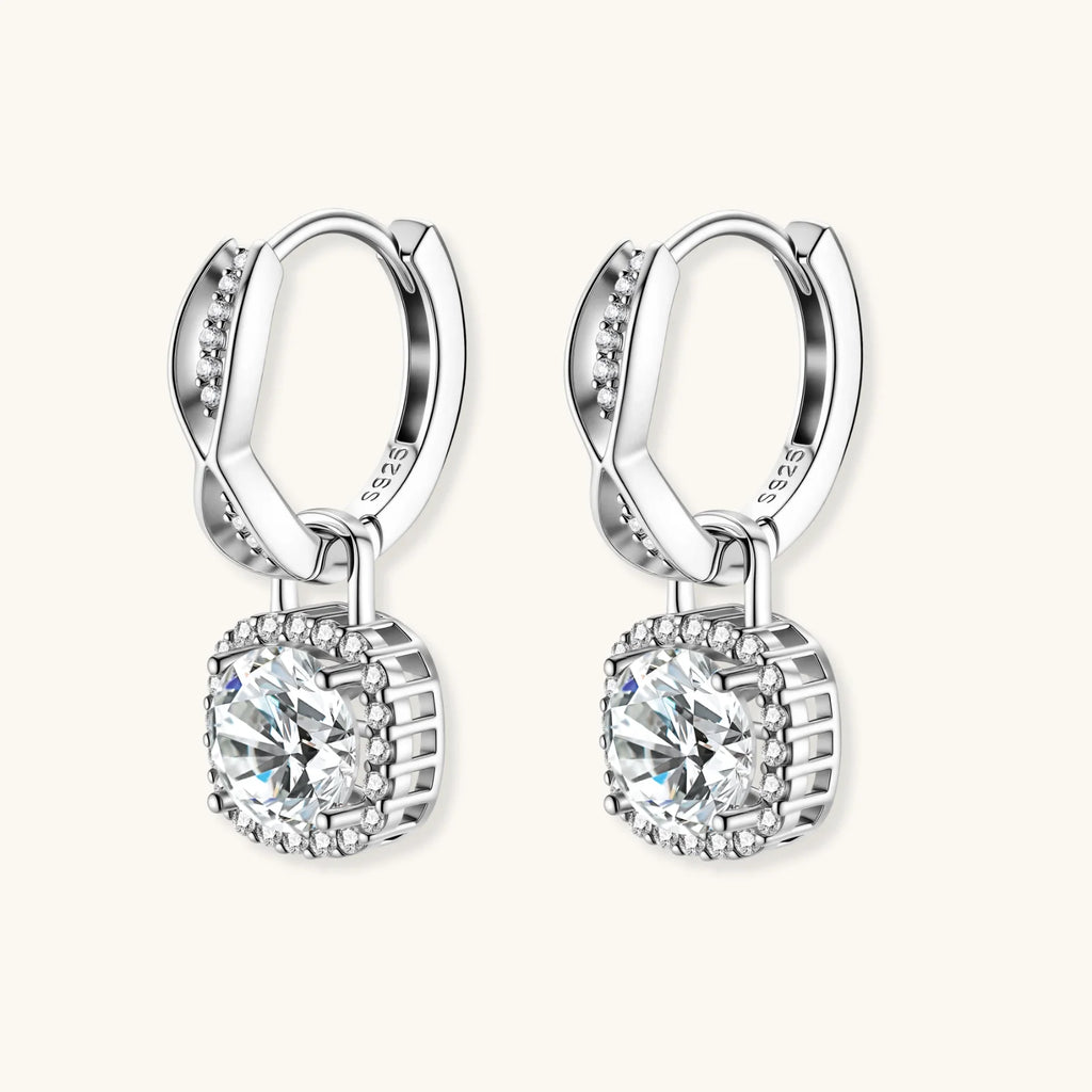 Sterling silver twisted hoop earrings with round moissanite stones in halo settings against neutral background.