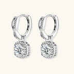 Sterling silver twisted hoop earrings with round moissanite stones in halo settings against neutral background.