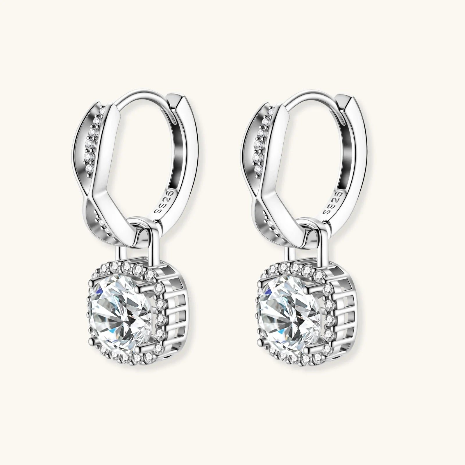 Sterling silver twisted hoop earrings with round moissanite stones in halo settings against neutral background.