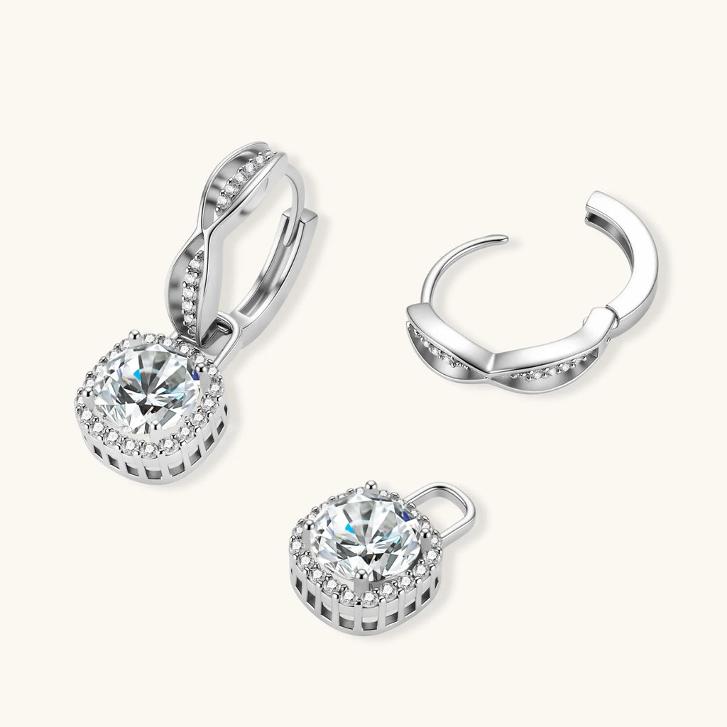 Sterling silver twisted hoop earrings with round moissanite stones in halo settings against neutral background.