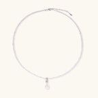 Dainty necklace with lavender crystal beads, freshwater pearls, geometric pendant, and large pearl drop on white background.
