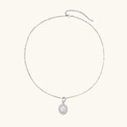 Oval sterling silver pendant with crystal halo surrounding a white freshwater pearl on delicate chain