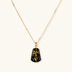 18k gold-plated necklace and earrings with green amber pendants featuring golden inclusions on cream background