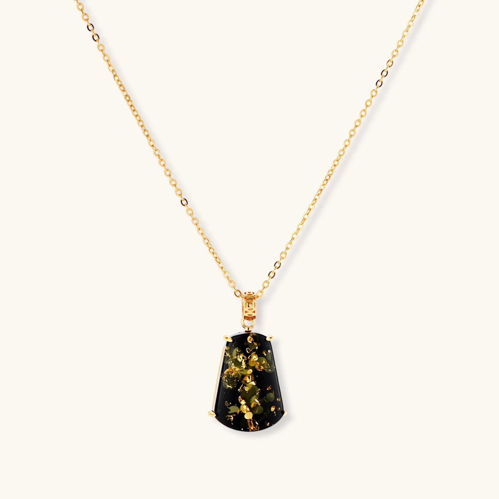 18k gold-plated necklace and earrings with green amber pendants featuring golden inclusions on cream background