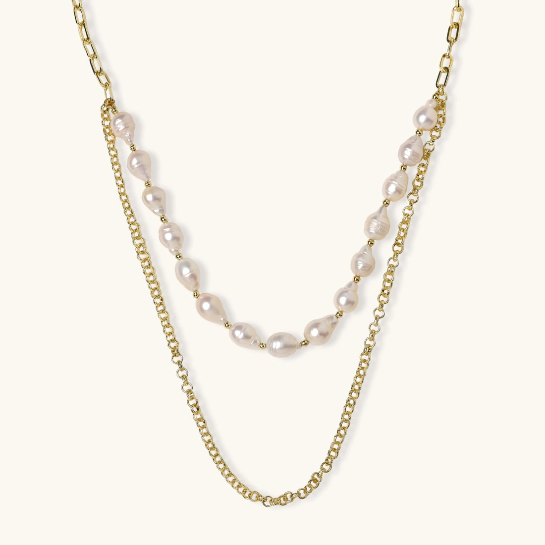 Layered gold chain necklace with organic baroque freshwater pearls and adjustable length on cream background
