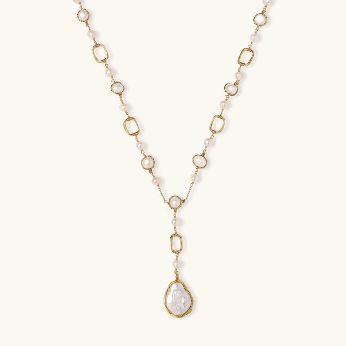 Long gold-plated necklace with alternating freshwater pearls and crystal bezels, featuring a large baroque pearl pendant