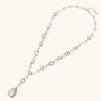 Long gold-plated necklace with alternating freshwater pearls and crystal bezels, featuring a large baroque pearl pendant