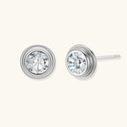 Close-up of sterling silver stud earrings featuring concentric circular frames with brilliant moissanite centers