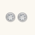 Close-up of sterling silver stud earrings featuring concentric circular frames with brilliant moissanite centers