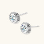 Close-up of sterling silver stud earrings featuring concentric circular frames with brilliant moissanite centers