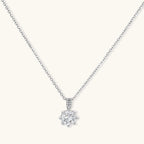 Platinum-plated sterling silver necklace with round clear crystal pendant and decorative bail on neutral background.