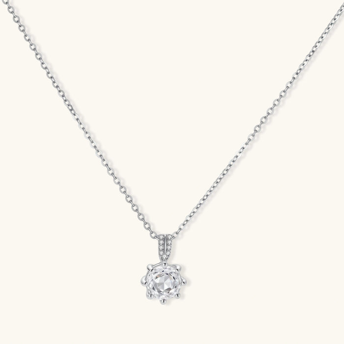 Platinum-plated sterling silver necklace with round clear crystal pendant and decorative bail on neutral background.
