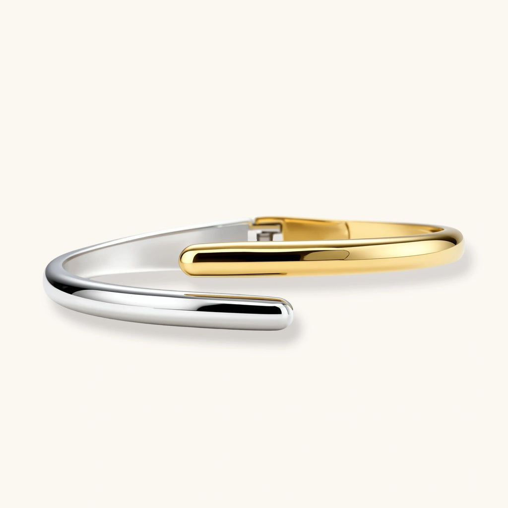 Polished two-tone bypass cuff bracelet in 18K gold plated and silver stainless steel with overlapping tapered ends.