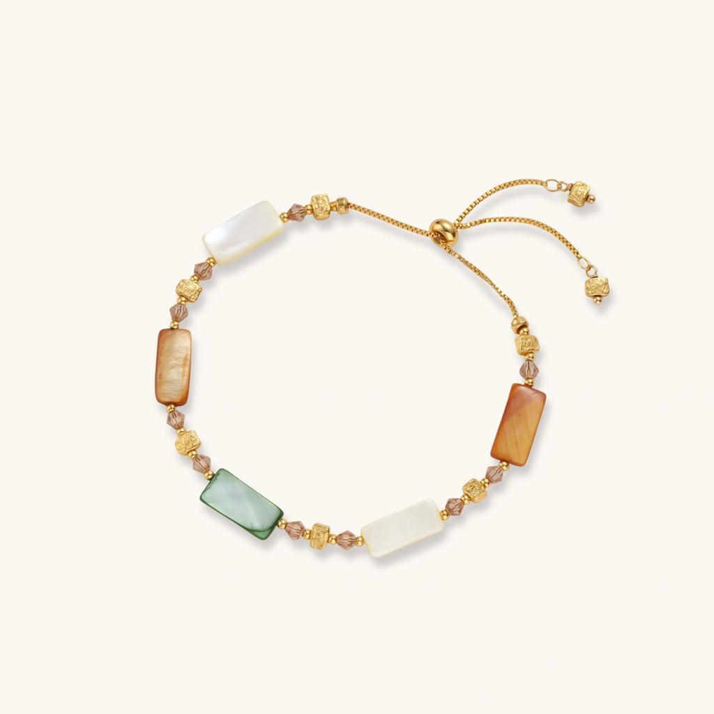 Adjustable gold-plated bracelet featuring rectangular shell beads in green, orange, and white tones on cream background.