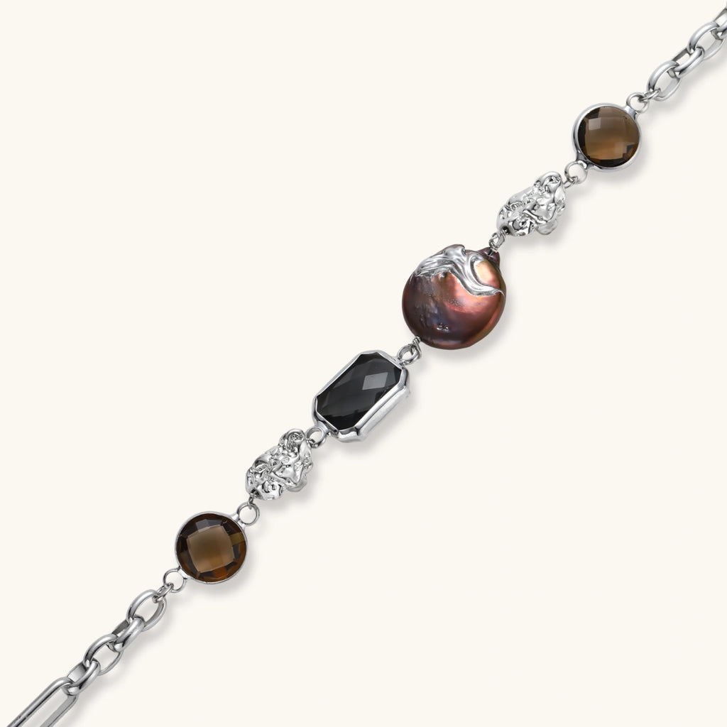 Chain bracelet with amber stones, baroque pearl, and dark rectangular stone on white gold-plated copper base.